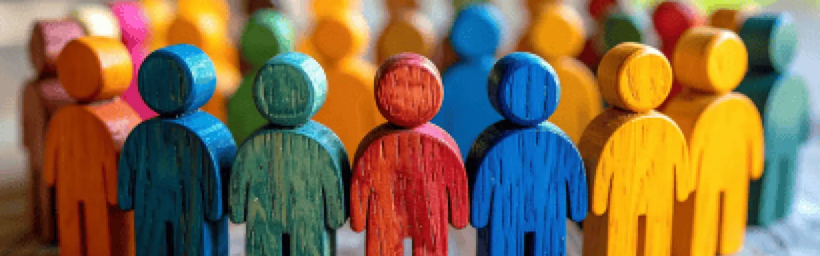 colorful, simple people figurines made of wood and arranged in a circle